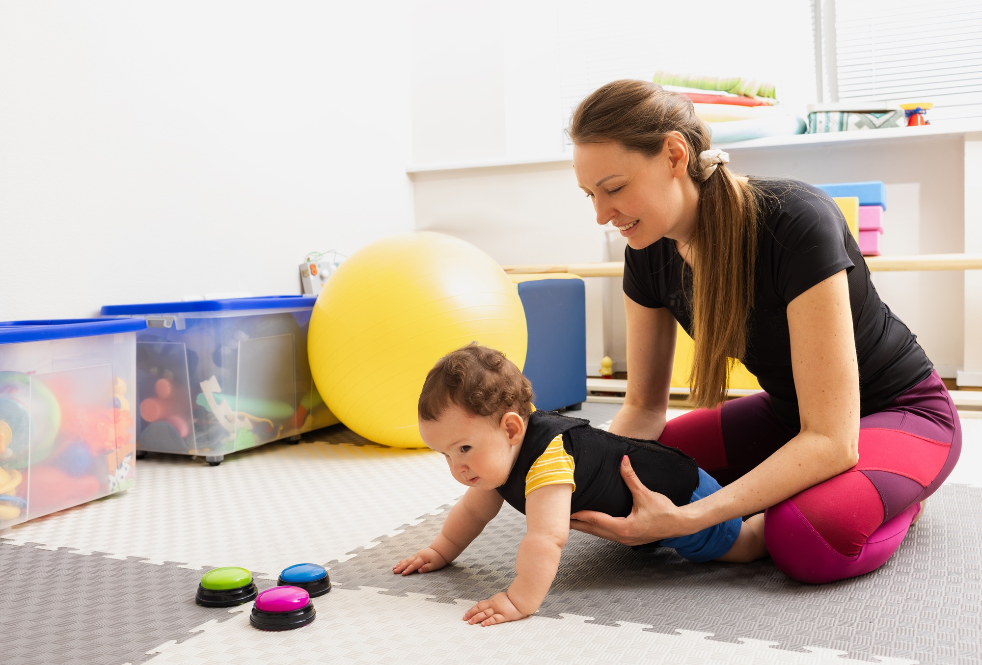 Child in orthopedic corset is engaged in exercises to restore and improve movements of his body.