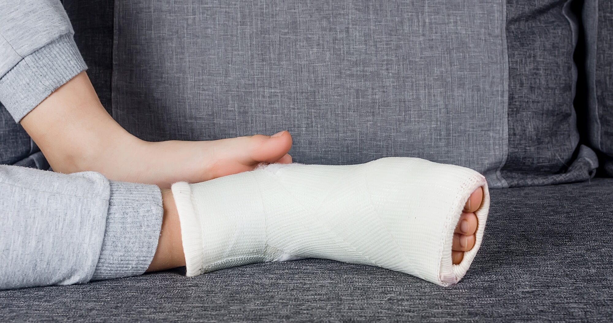 Child with Plaster bandage on leg cast and toes after injury fracture, dislocation, sprain.